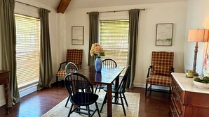 A dining area with a wooden table, chairs, and a vase of flowers. - Oxford at its Best! Location, Layout, Privacy!! (Oxford)