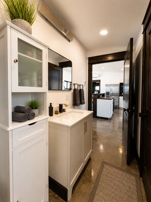A modern bathroom with a white vanity, a large mirror, a sink, and a potted plant. - Modern Mountain Escape 2 Bed, 2 Bath 360 degree Sangre Views (Westcliffe)