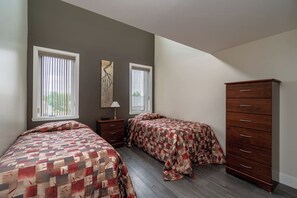 A bedroom with two beds, a dresser, and a nightstand. - Stunning 2-bedroom condo with pools and spa! (Beaupré)