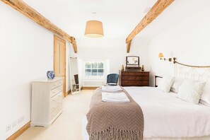 Une chambre à coucher avec un lit, une commode et une fenêtre.