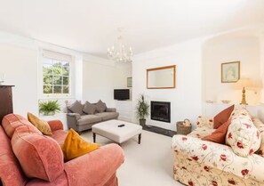 Ein Wohnzimmer mit Kamin, Sofas und Fernseher.
