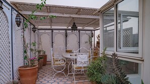 A covered patio area with a table and chairs, potted plants, and a decorative metal tray. - Authentic house in the old Medina of Marrakech. Taste the Moroccan culture (Marrakech)
