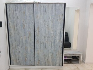 A room with a large wardrobe, a mirror, and a small table with shoes. - Cozy 1-bedroom apartment in the Baku center (Bakı)