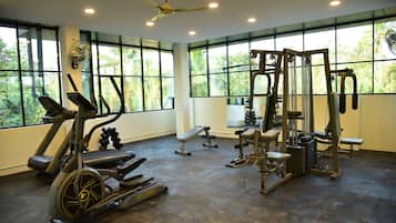 A gym with cardio equipment, weight machines, and benches.