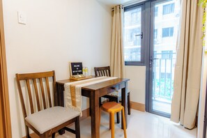 Espaço de refeições com mesa, cadeiras, uma placa e vista por uma porta.