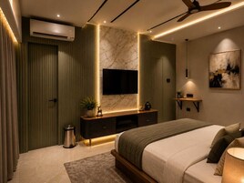 Un dormitorio moderno con cama, televisor montado en la pared, ventilador de techo y pared con diseño de mármol.