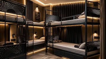 Habitación con literas, ventilador de techo, una cita motivacional enmarcada y alfombra estampada.