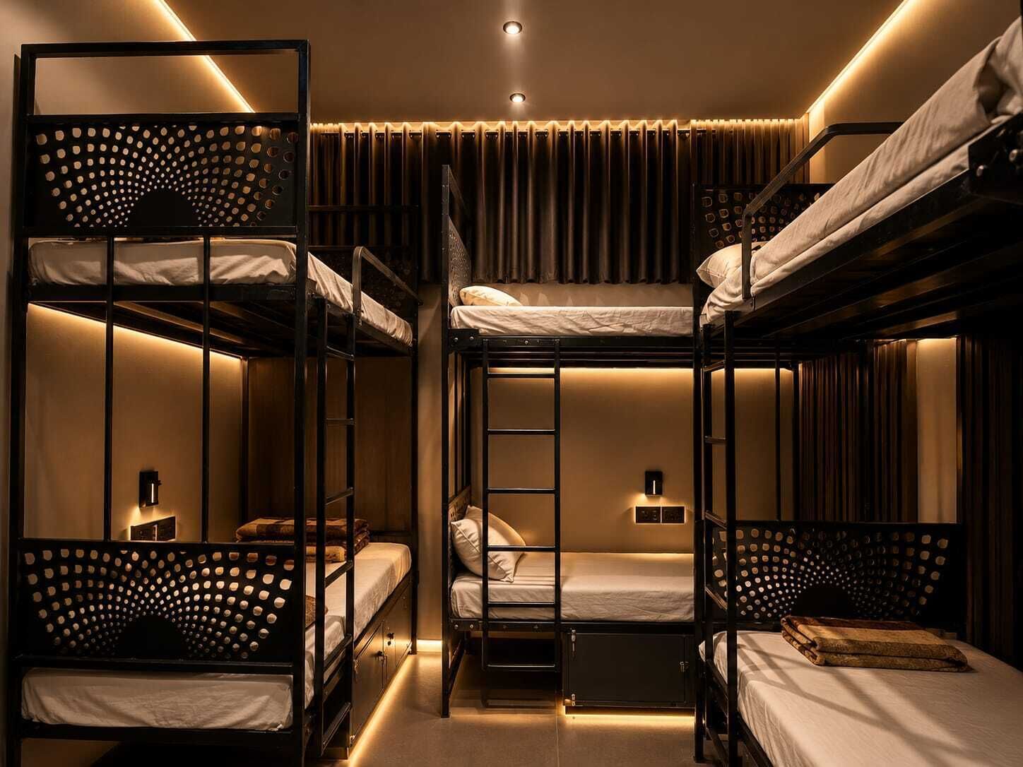 A bunk bed room with a ladder, a small table, and a wall-mounted light fixture.