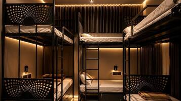 A bunk bed room with a ladder, a small table, and a wall-mounted light fixture.