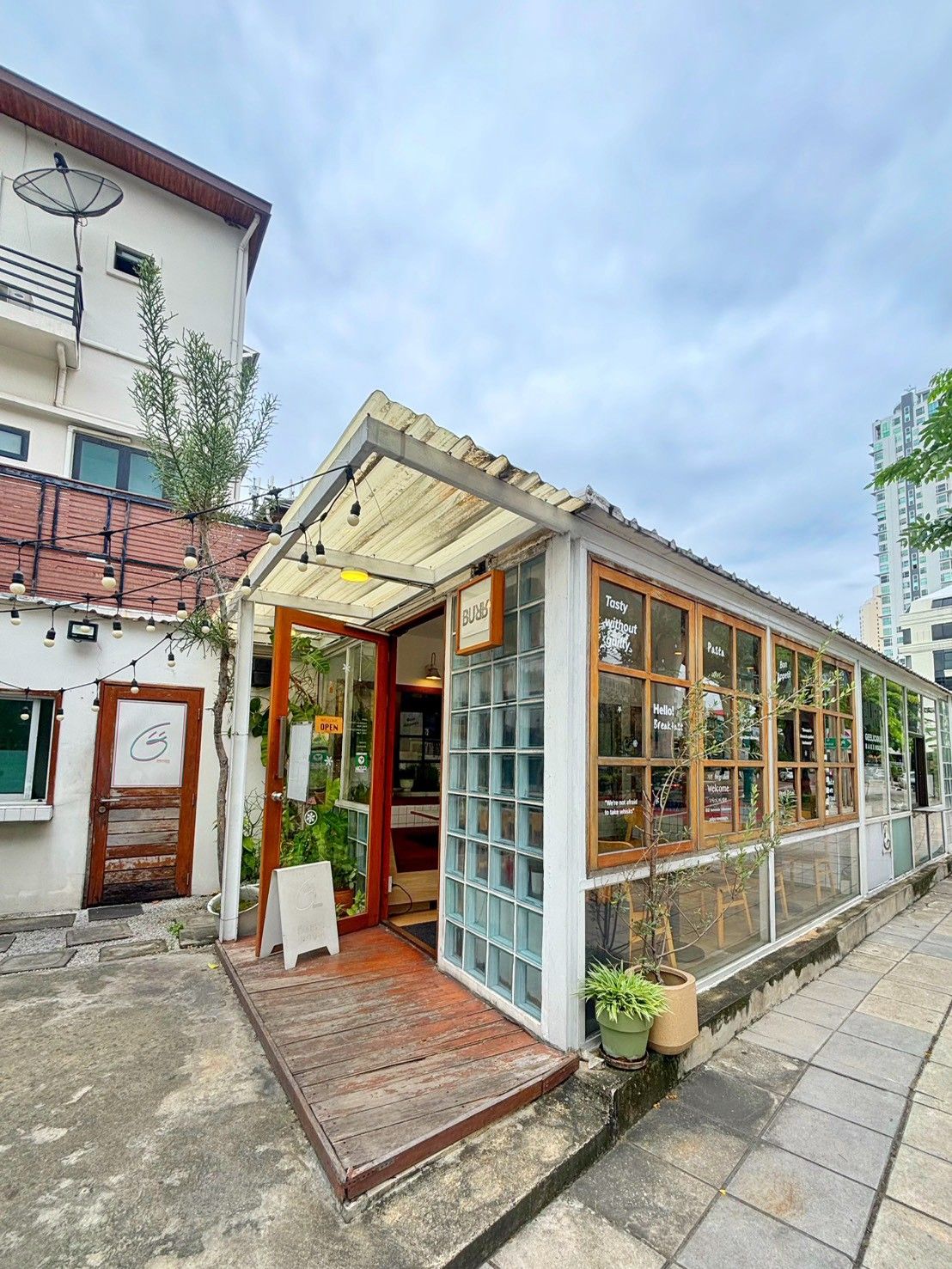 A small, single-story building with a wooden deck and a glass storefront.