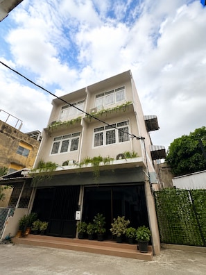 A multi-story building with a flat facade, large windows, and a covered entrance. - Charoennakhon 14 (Krung Thep Maha Nakhon)