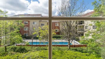 Ein Wohngebäude mit Swimmingpool, umgeben von Grünflächen.