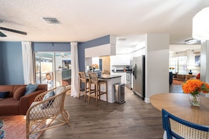 A modern kitchen with a central island, bar stools, and a stainless steel refrigerator. - Palm Harbor Heated Pool Resort - Theater Mini Golf (Palm Harbor)