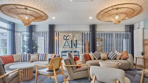 Uma sala de estar moderna com um conjunto de sofás, uma mesa de centro e uma área de refeições.