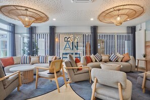 A modern living room with a sofa set, a coffee table, and a dining area. - Royan : appartement de prestige en bord de mer (Royan)