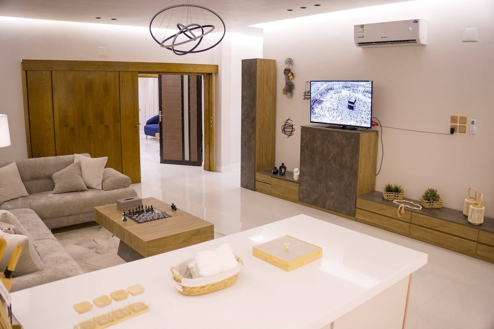 Una sala de estar moderna con un sofá, una mesa de centro y un televisor montado en la pared.