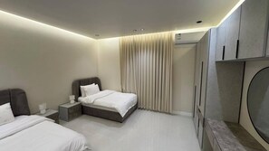 A modern hotel room with a bed, bedside tables, a TV, and a wardrobe. -  فيلا دورين بتأثيث فندقي فاخر وجلسة  خارجية (Al Bahah)