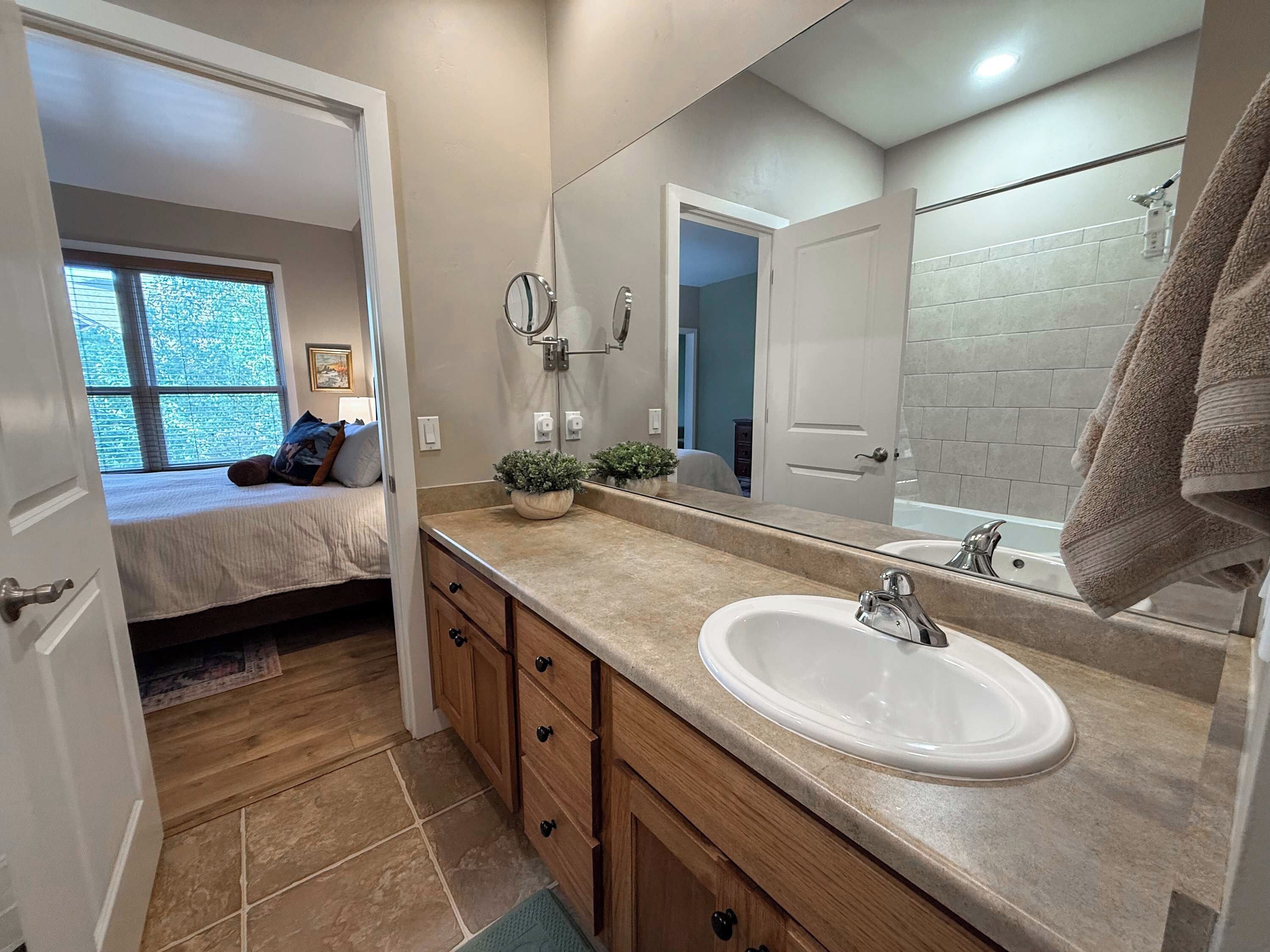 A bathroom with a sink, mirror, and towel rack.