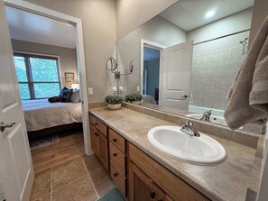 A bathroom with a sink, mirror, and towel rack. - Long Term | 1 BR/1.5BA | Communal Pool & Hot Tub (Whitefish)
