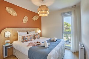 Ein Hotelzimmer mit einem großen Bett, einem Nachttisch, Vorhängen und einer Deckenleuchte.