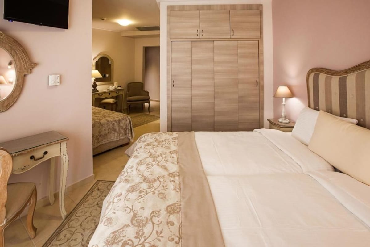 Quarto com cama, mesa de cabeceira, luminária e guarda-roupa.