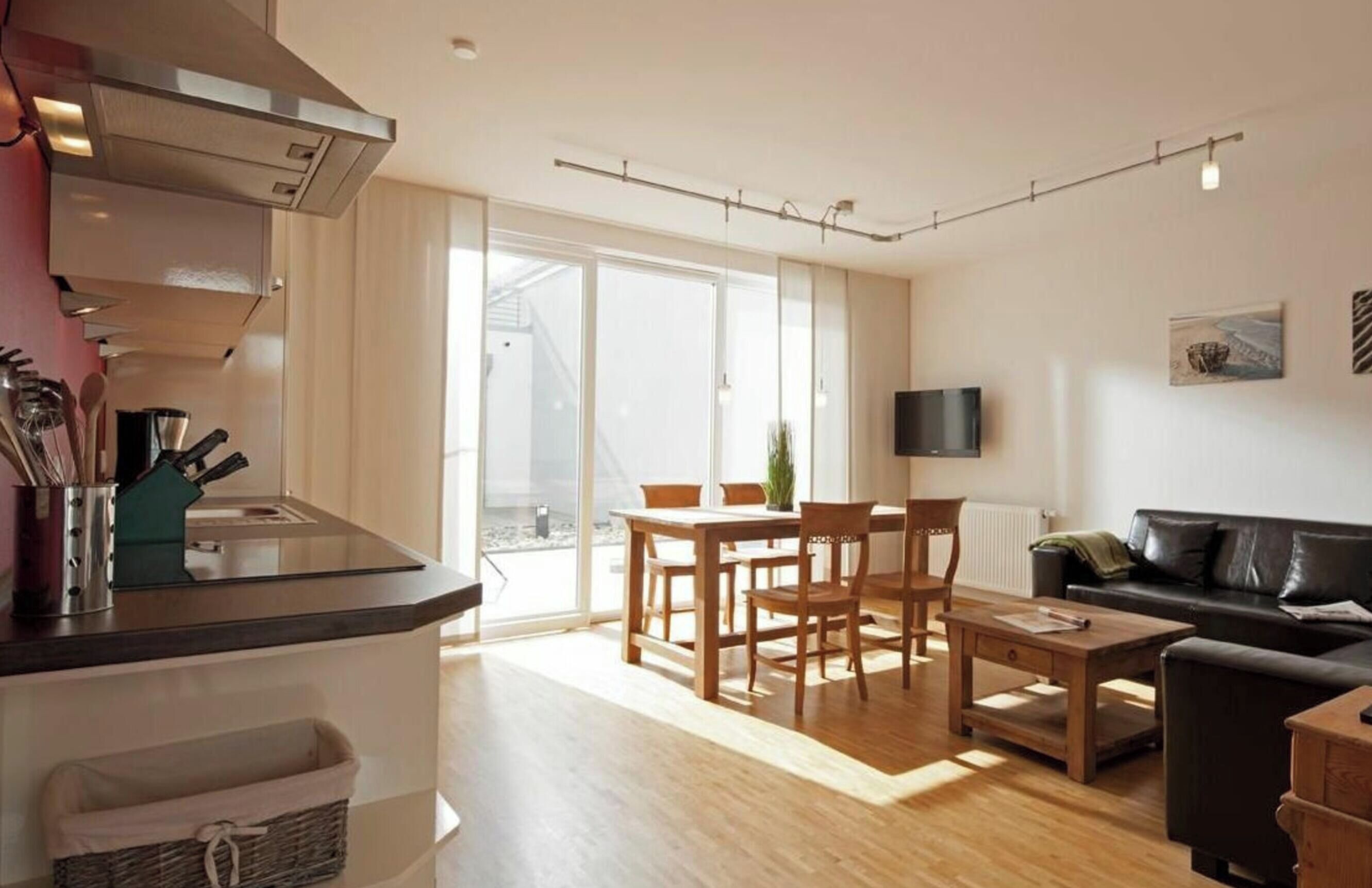 A modern apartment with a kitchen, dining area, and living room.