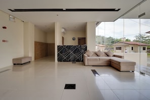 A modern interior with a sofa, a tiled floor, and a large window. - Nagi 凪 Quiet Studio Stay with AC (Lapu-Lapu)