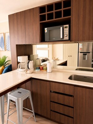 Eine moderne Küche mit Mikrowelle, Kühlschrank und Kaffeemaschine.