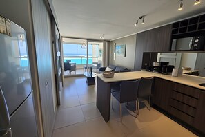 Eine moderne Küche mit Essbereich, einem Kühlschrank und Meerblick.
