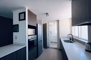 A modern kitchen with a built-in oven, a microwave, and a stainless steel refrigerator. - Peace, Sea and Space to Enjoy Laguna del Mar (La Serena)