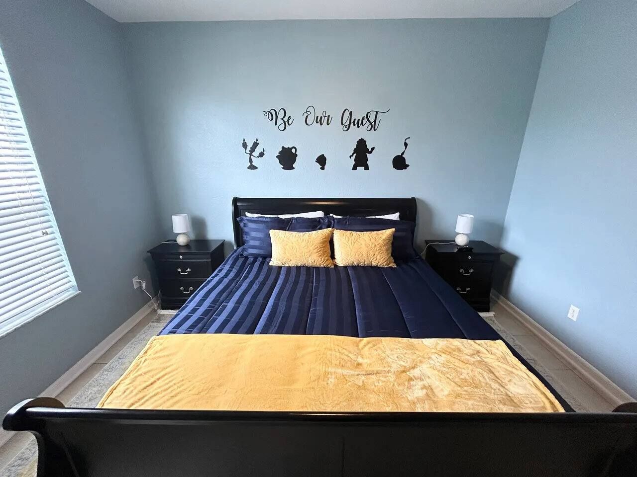 A bedroom with a bed, two bedside tables, and a wall decoration.