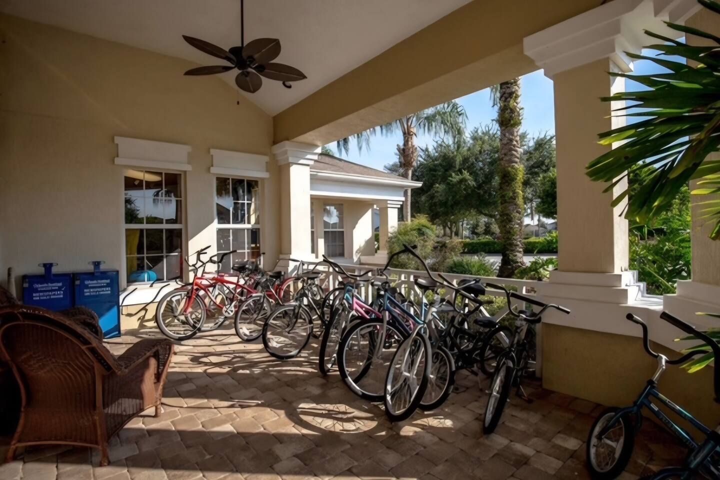 A covered outdoor area with bicycles parked and a ceiling fan.