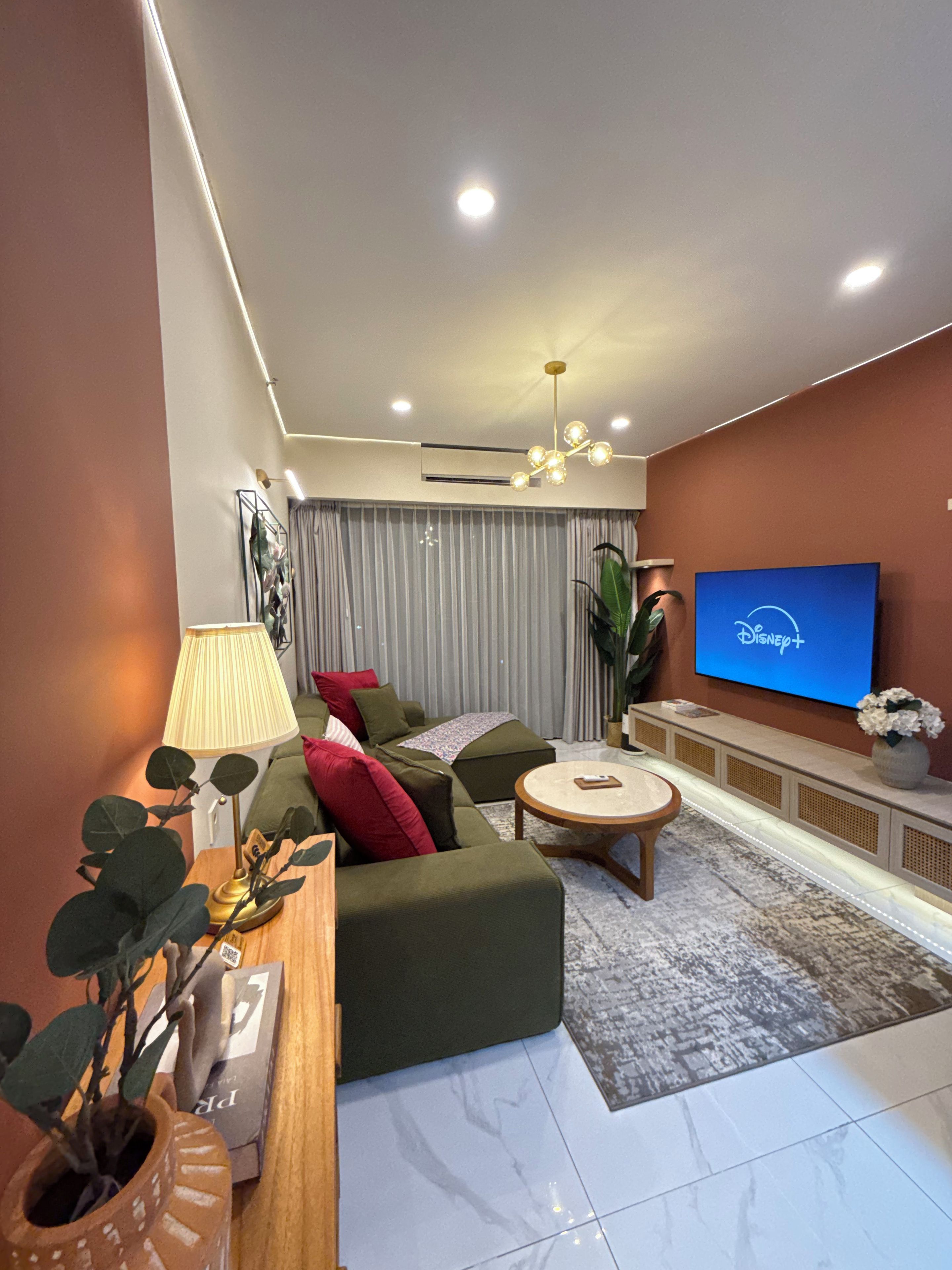 A modern living room with a sofa, a coffee table, a TV, and a lamp.