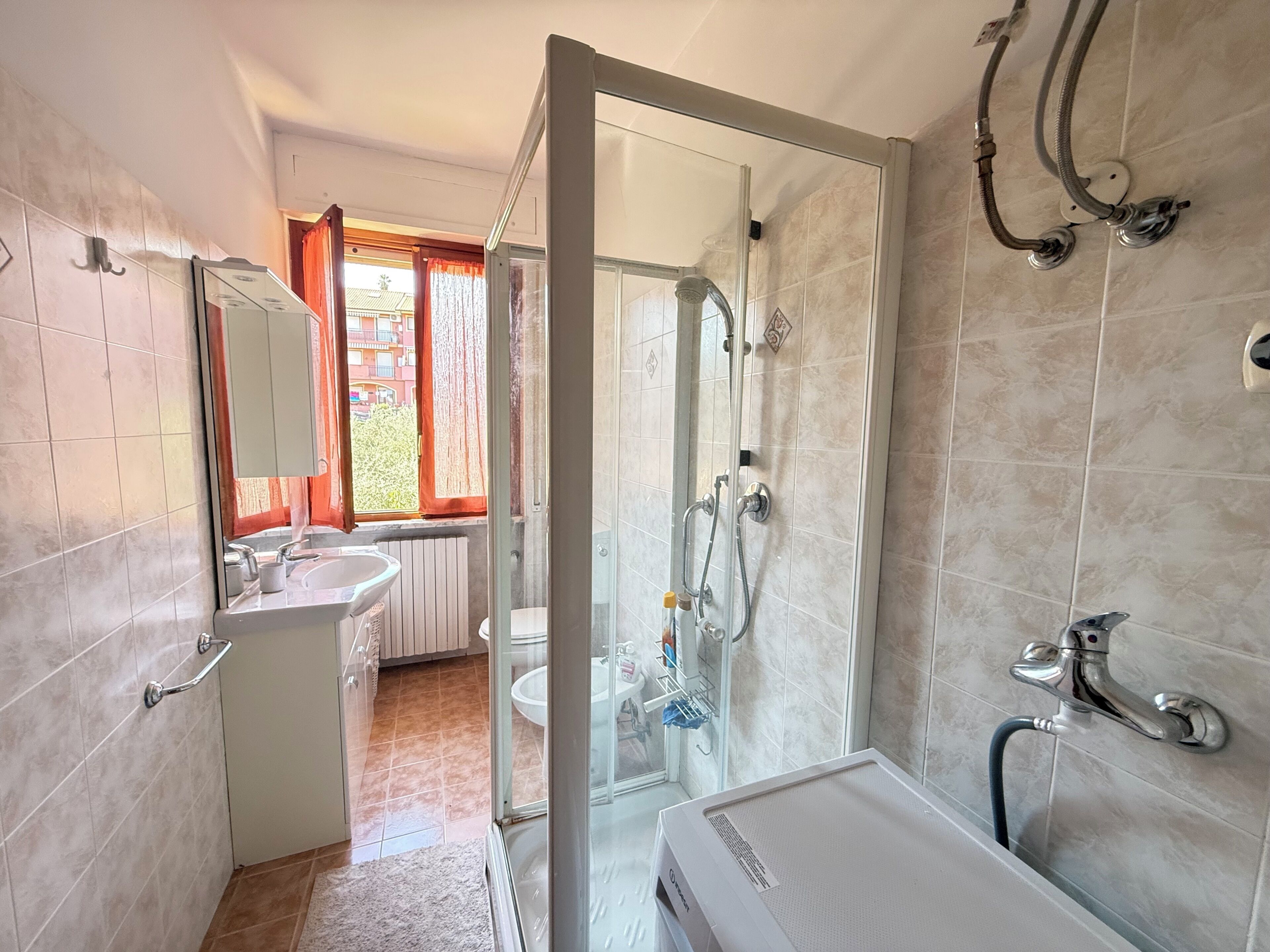 Une salle de bain avec une douche à parois de verre, un lavabo et des toilettes.