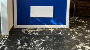 Een receptie met een blauwe balie, een ventilator en een bord dat een receptiebalie aangeeft.