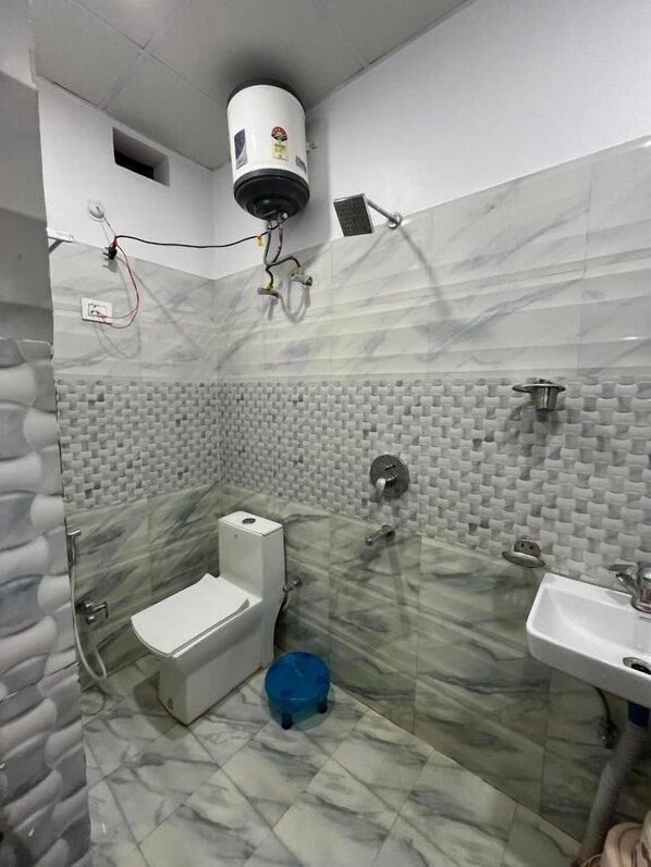 A bathroom with a toilet, sink, and shower area.