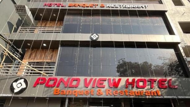 Een hotel met een bord waarop 'Pond View Hotel' en 'Banquet & Restaurant' staat, wat een eetruimte aangeeft.