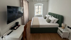 A bedroom with a bed, a TV, a desk, and a window. - The Roots Dubrovnik (Dubrovnik)