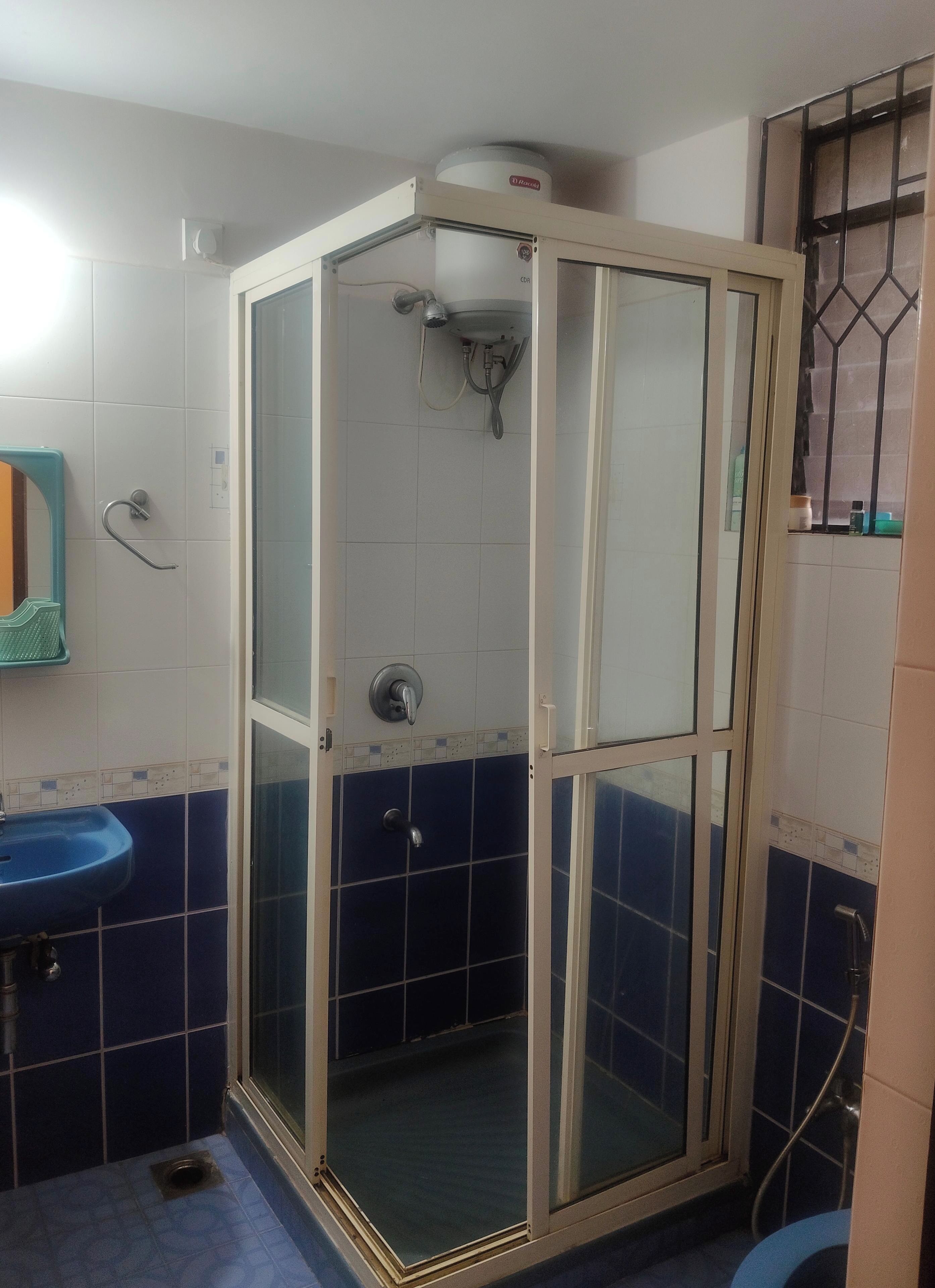A bathroom with a glass-enclosed shower, a sink, and a toilet.