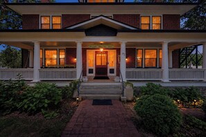 A two-story brick building with a porch, a sign reading 'Sweet Biscuit Inn,' and a number '77' on the facade. - Sweet Biscuit Inn | 8BR • 2 Mi to Biltmore (Asheville)