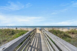 A wooden boardwalk leading to a beach with the ocean in the distance. - Ocean Garden Villas B3- Oceanfront 2 Bedroom (North Myrtle Beach)