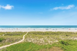 A beach with a clear sky, a sandy shore, and a path leading to the beach. - Ocean Garden Villas B3- Oceanfront 2 Bedroom (North Myrtle Beach)