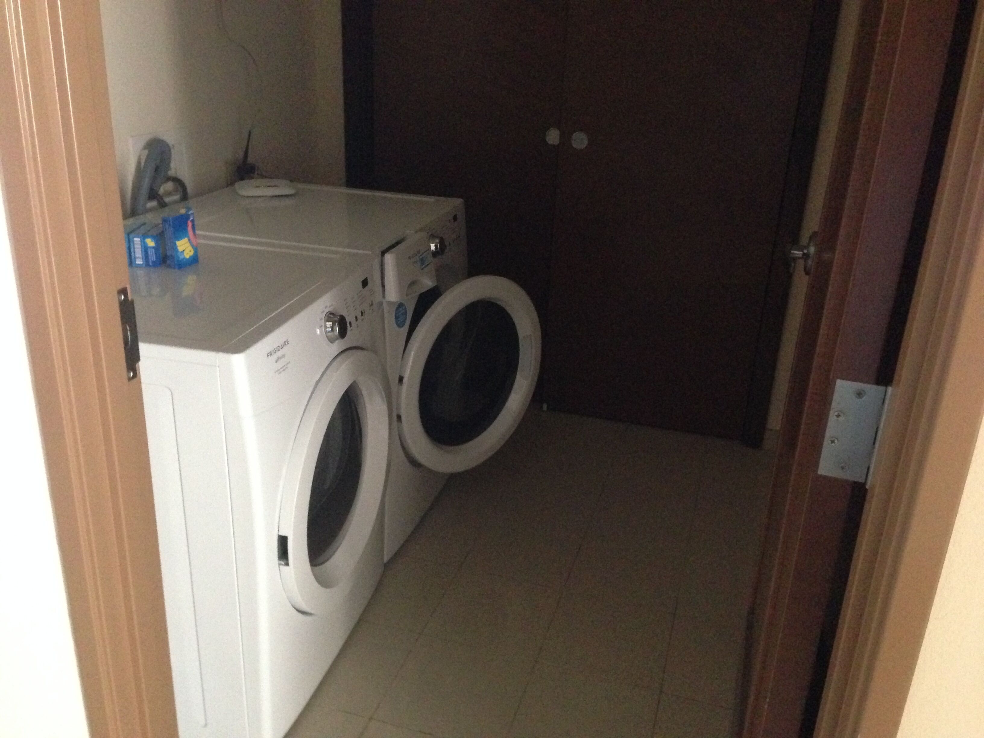 A laundry room with two stacked washing machines and a dryer.