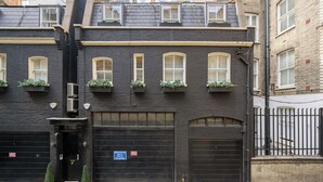 Un bâtiment à deux étages avec une façade noire, de nombreuses fenêtres dotées de cadres blancs et une porte de garage.