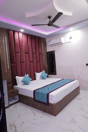 A bedroom with a bed, a ceiling fan, an air conditioning unit, and a wardrobe. - Hotel The Grand Bareilly (Bareilly)