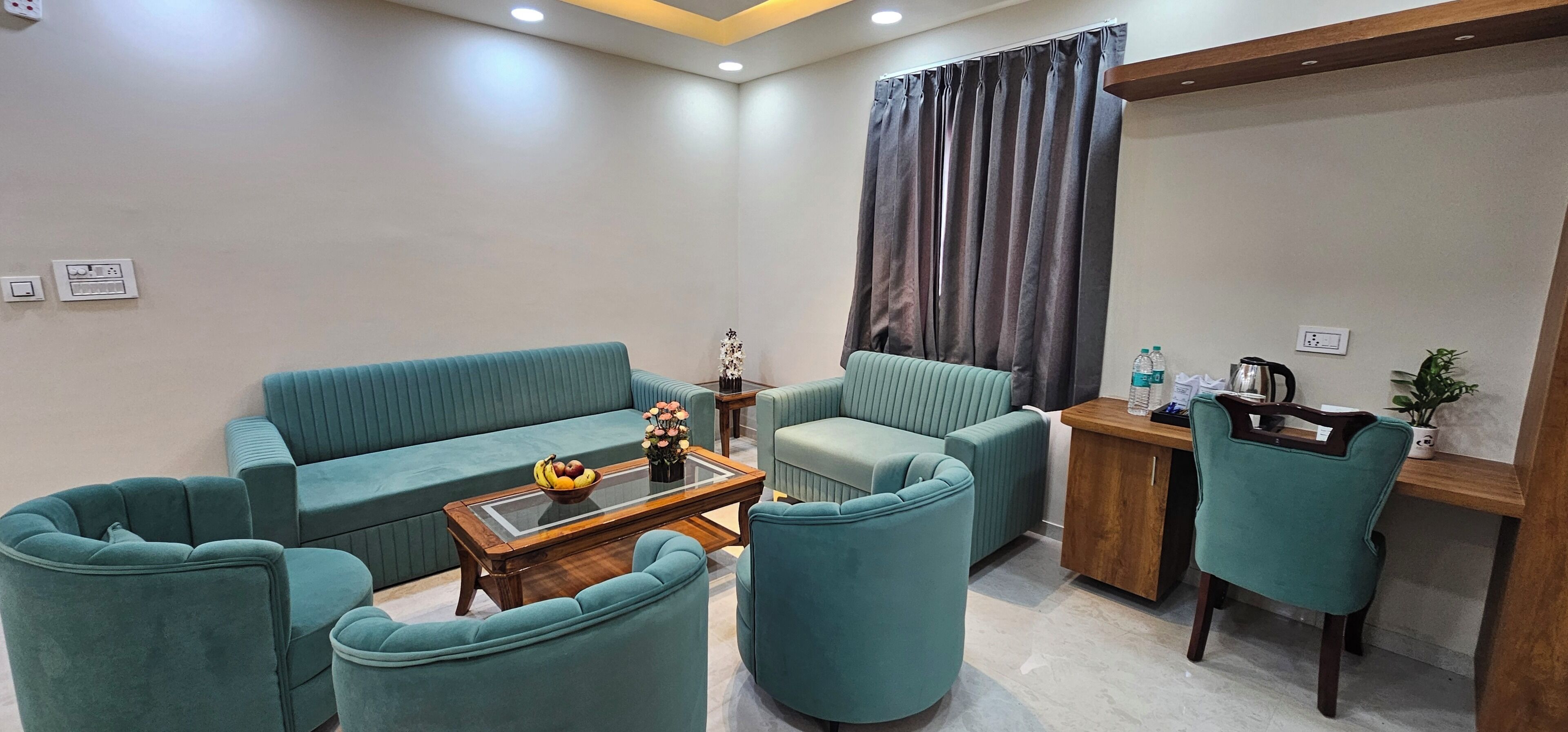 Sala de estar moderna com sofás cor turquesa, uma mesa de centro e uma pequena mesinha de madeira.