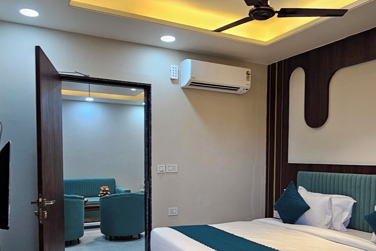 A modern bedroom with a bed, a ceiling fan, and an air conditioning unit.