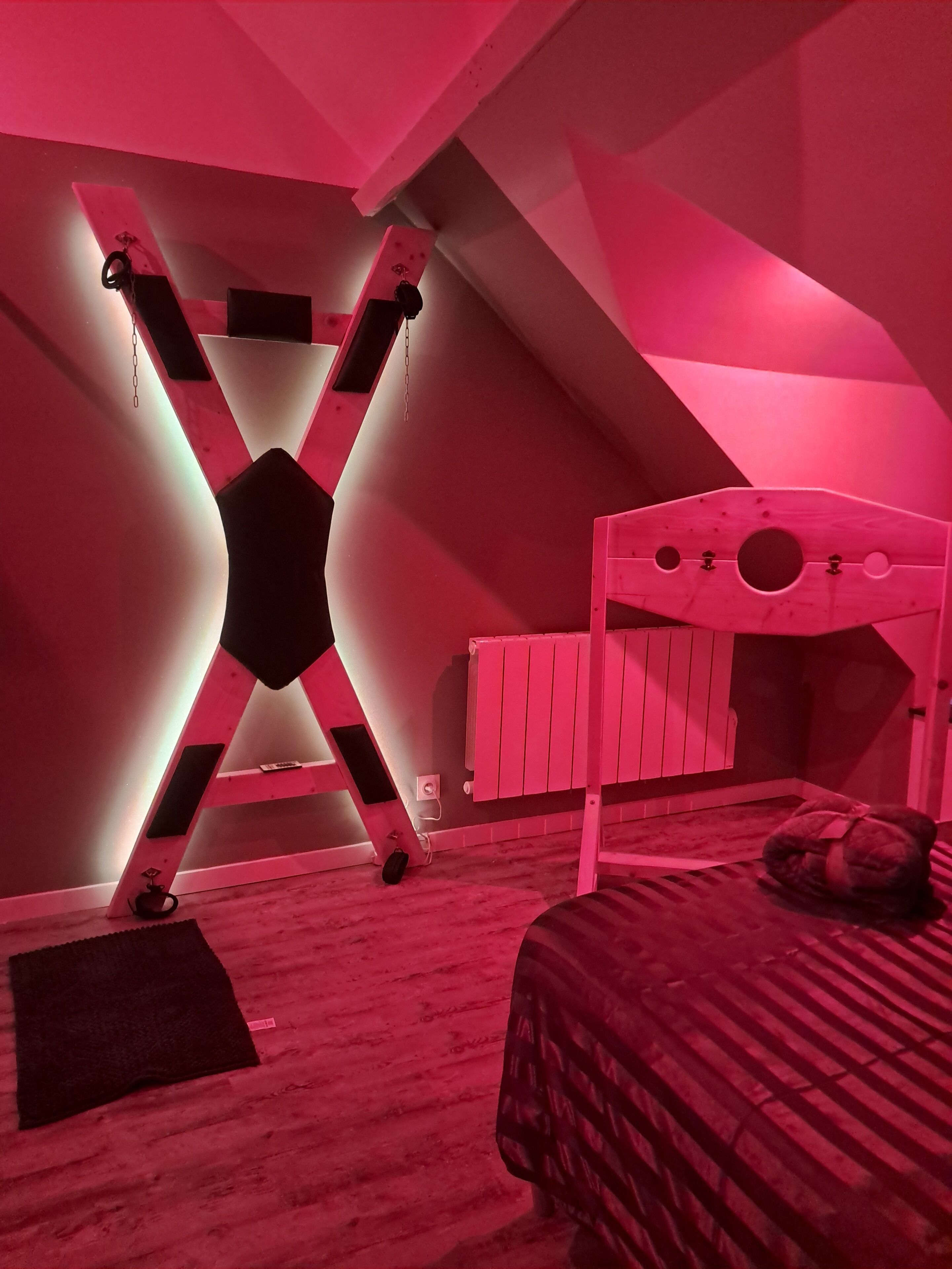 Een kamer met een stapelbed, een schuine plafond en een radiator.