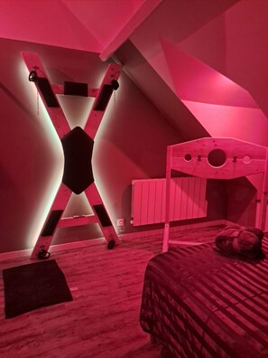 A room with a bunk bed, a slanted ceiling, and a radiator.