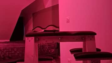 Een kamer met een bank, een aan de muur hangend schilderij en een schuin dak.